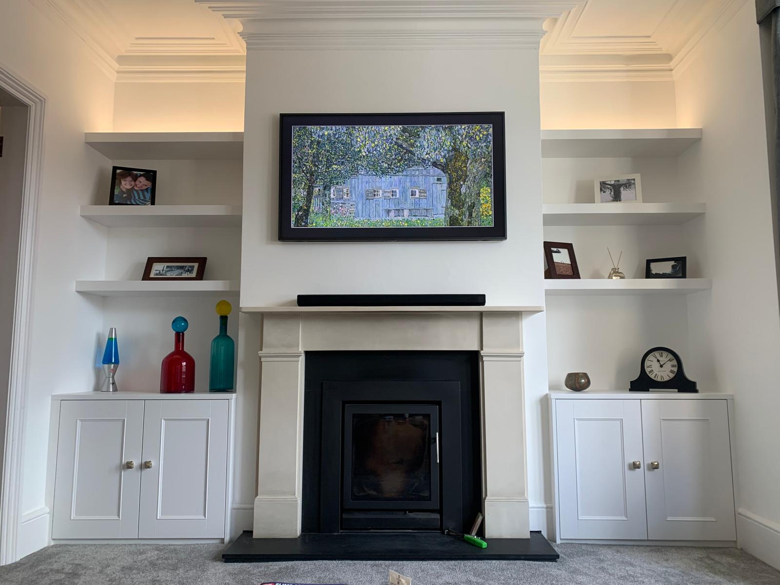 Fitted media wall with integrated shelving in Windsor home